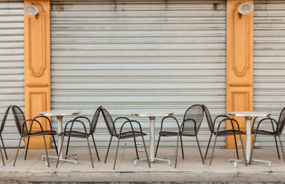 Empty chairs and table against wall