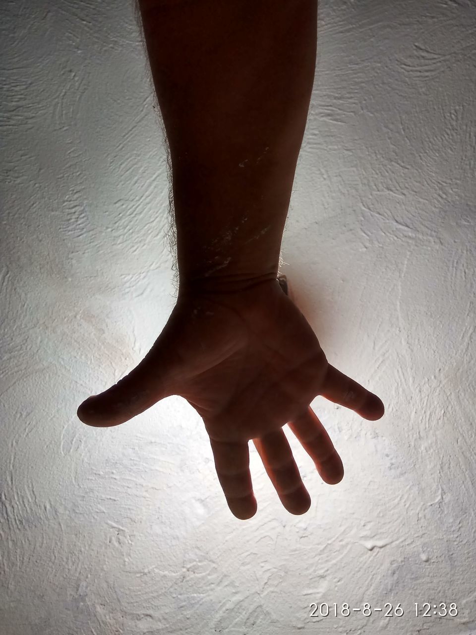 LOW SECTION OF WOMAN WITH HAND ON WALL