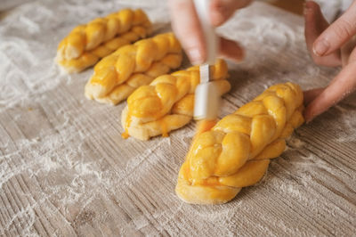 Cropped image of hand making breads on table