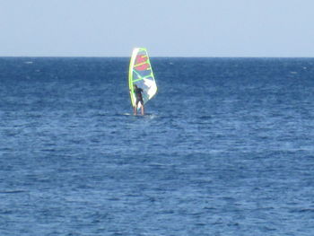 Man standing in sea against clear sky