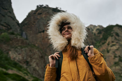 Rear view of woman standing against mountain