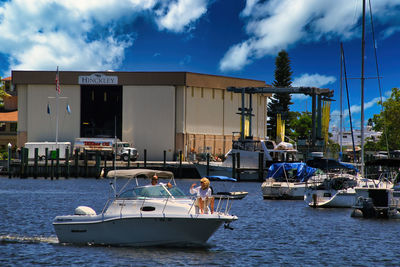 Sailboats moored on sea against buildings