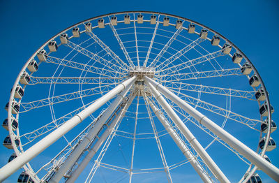 Low angle view of ferris wheel against blue sky