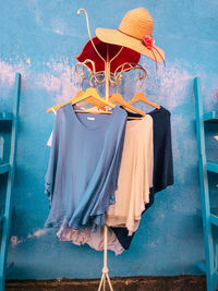 Close-up of clothes hanging on chair against blue wall