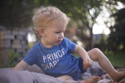 Portrait of boy looking away while sitting outdoors