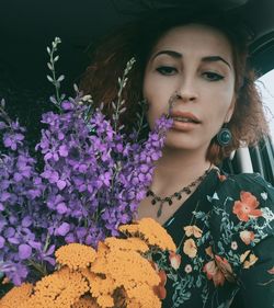 Portrait of beautiful woman by purple flowering plants