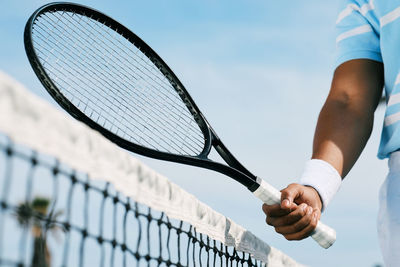 Midsection of man playing tennis