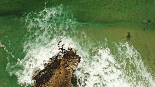 High angle view of wave splashing on rock