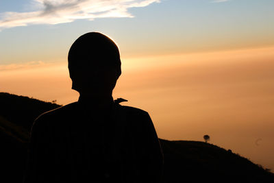 Silhouette man standing against sky during sunset