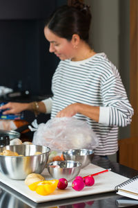 Side view of woman preparing food at table