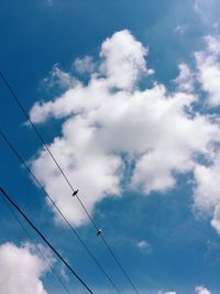 Low angle view of power lines against cloudy sky