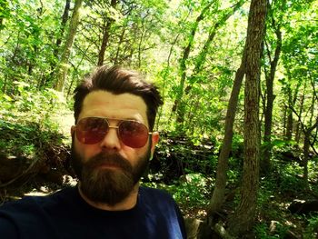 Portrait of young man in sunglasses at forest