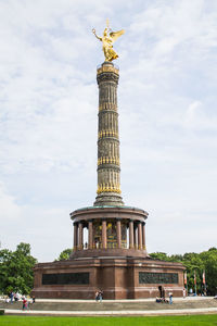 Low angle view of berlin victory column against cloudy sky