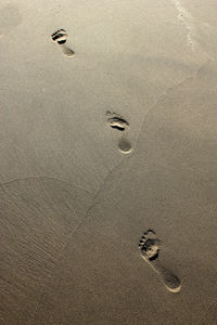 Close-up of footprints on sand at beach