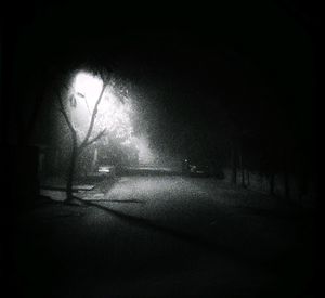 Silhouette person standing on street at night