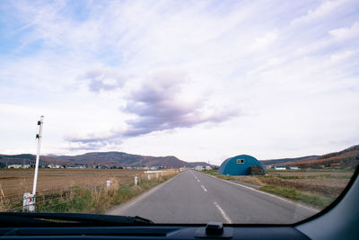 Road against sky seen through car windshield