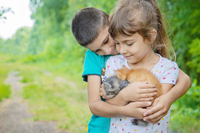 Brother and sisters embracing with kittens