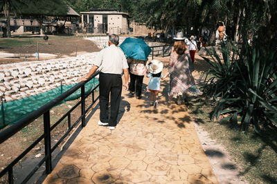 Rear view of people walking on road in city