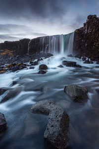 Scenic view of waterfall against sky