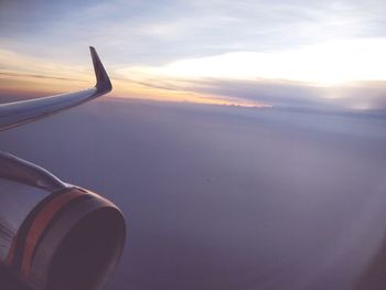 Airplane flying in sky at sunset