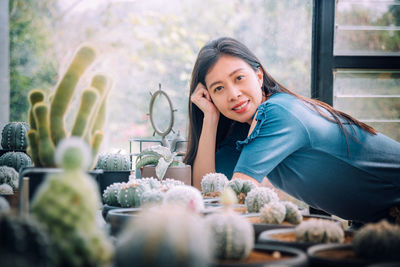 Portrait of smiling young woman sitting on table