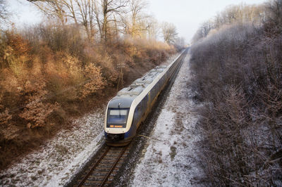 Railroad tracks by road during winter