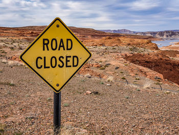 Information sign on road against sky