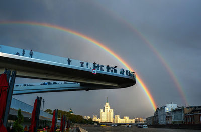 Rainbow over city against sky