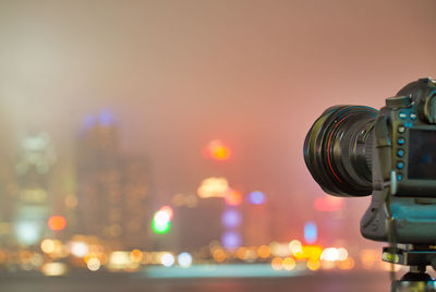 Close-up of illuminated cityscape against sky during sunset