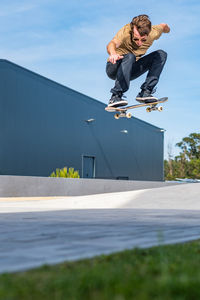 Low section of man skateboarding on road