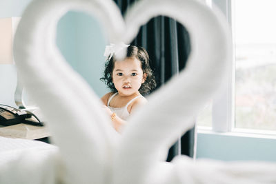 Portrait of girl sitting at home with love sign