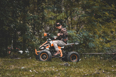 Motorcycle cart on street amidst trees in forest