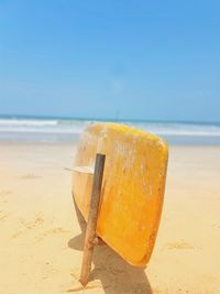 Close-up of ice cream on beach against sky