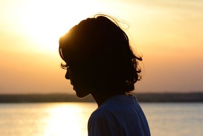 Portrait of boy against sea during sunset