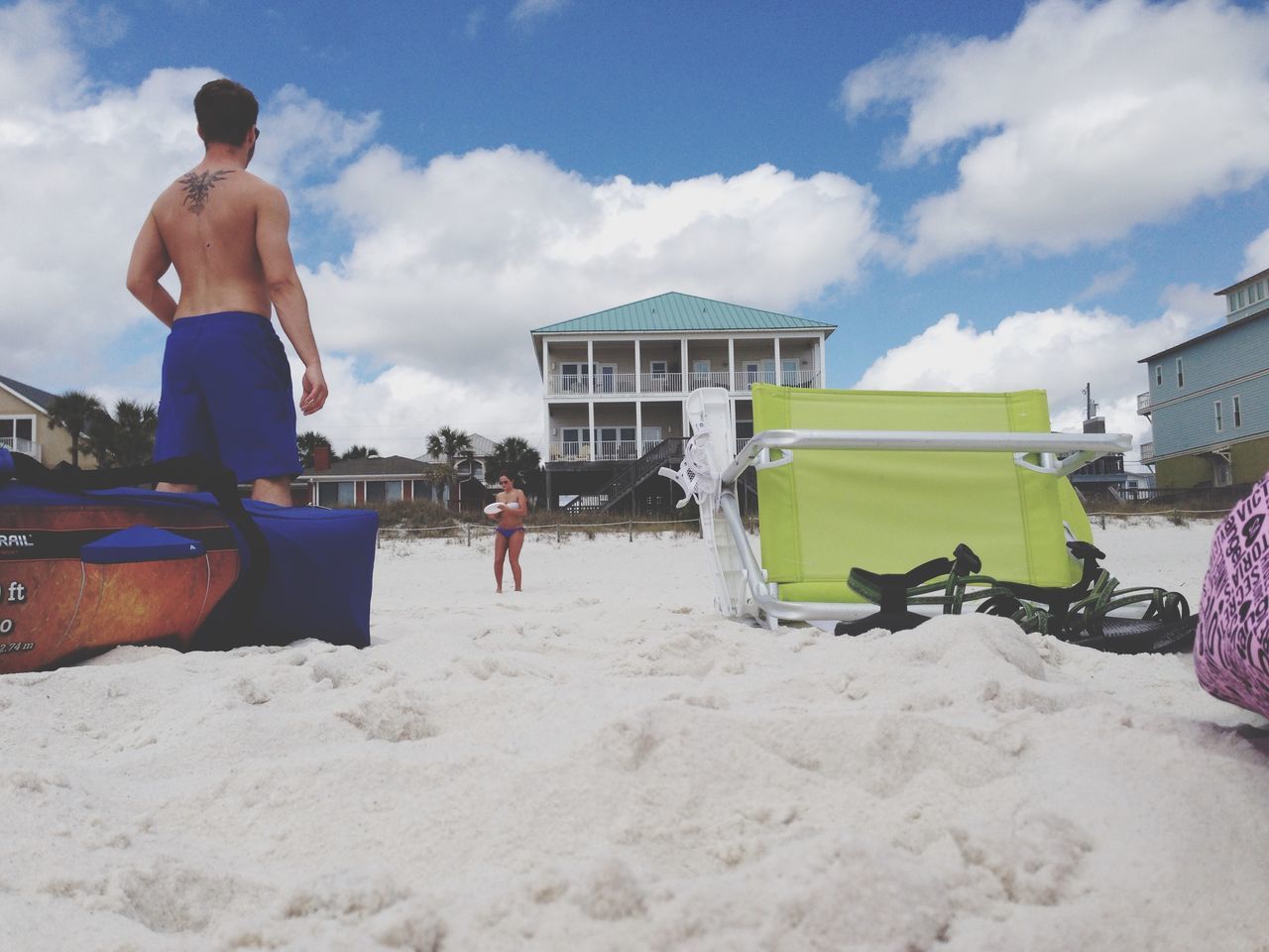 lifestyles, sky, leisure activity, men, cloud - sky, beach, built structure, building exterior, full length, casual clothing, architecture, sand, sitting, person, cloud, togetherness, day