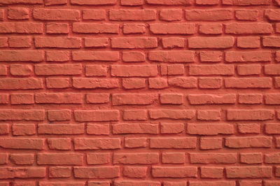 Front view of persian red colored old brick wall for background, texture or pattern