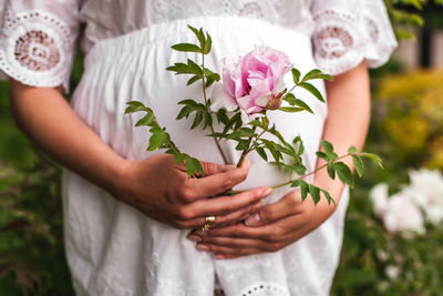 Midsection of woman holding flower bouquet