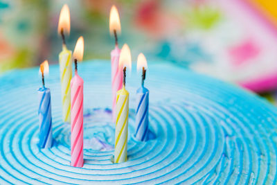 Close-up of multi colored candles on cutting board