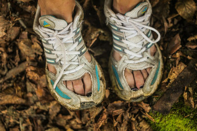 Low section of woman wearing abandoned shoes