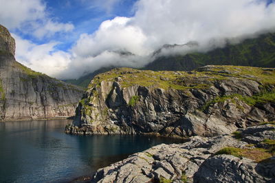 Scenic view of lake and mountains against cloudy sky