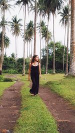 Portrait of young woman standing on field