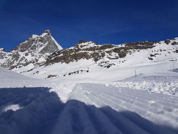 Snow covered mountain against blue sky