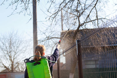 Fumigating pesti, pest control. defocus farmer woman spraying tree with green pesticide sprayer