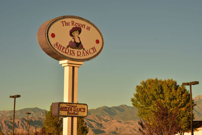 Low angle view of road sign against clear sky