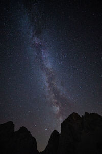 Low angle view of silhouette mountain against sky at night