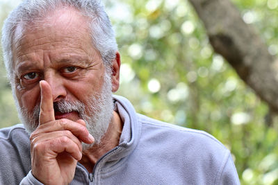 Portrait of senior man gesturing outdoors