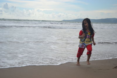 Portrait of young woman standing on beach