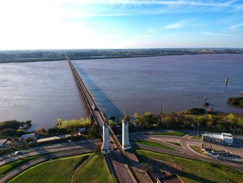 High angle view of city by sea against sky