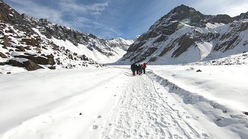 People on snowcapped mountain against sky