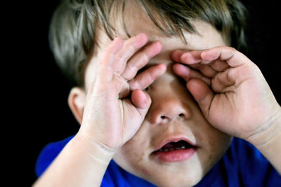 Close-up of boy rubbing eyes